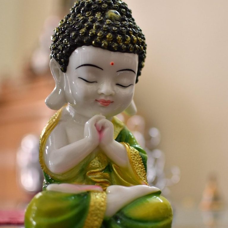 Porträt einer lächelnden Frau mit langen, grauen Haaren vor neutralem
